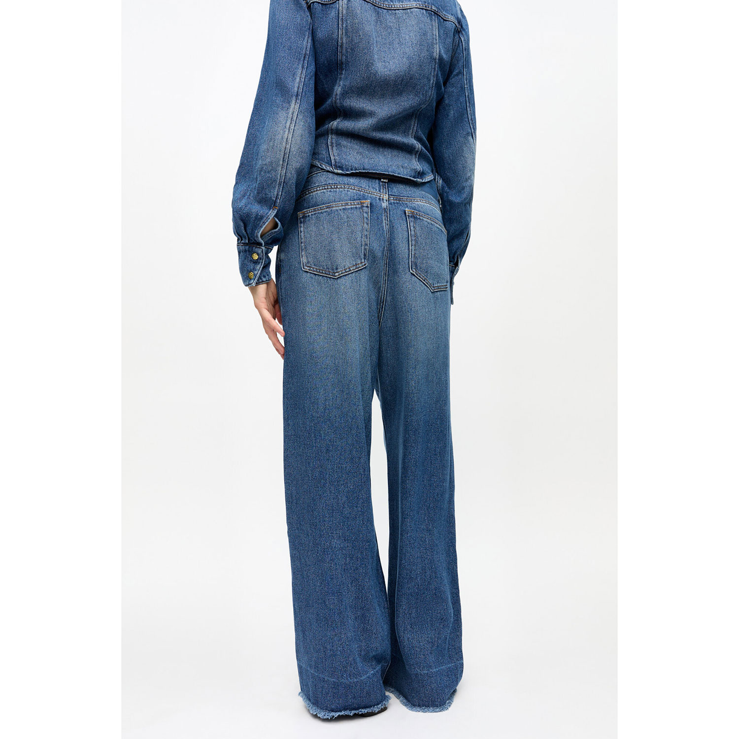 Ganni J1706 Jeanshose mit Falten und Verwaschungen in Denimblau von Ganni. Model hinten