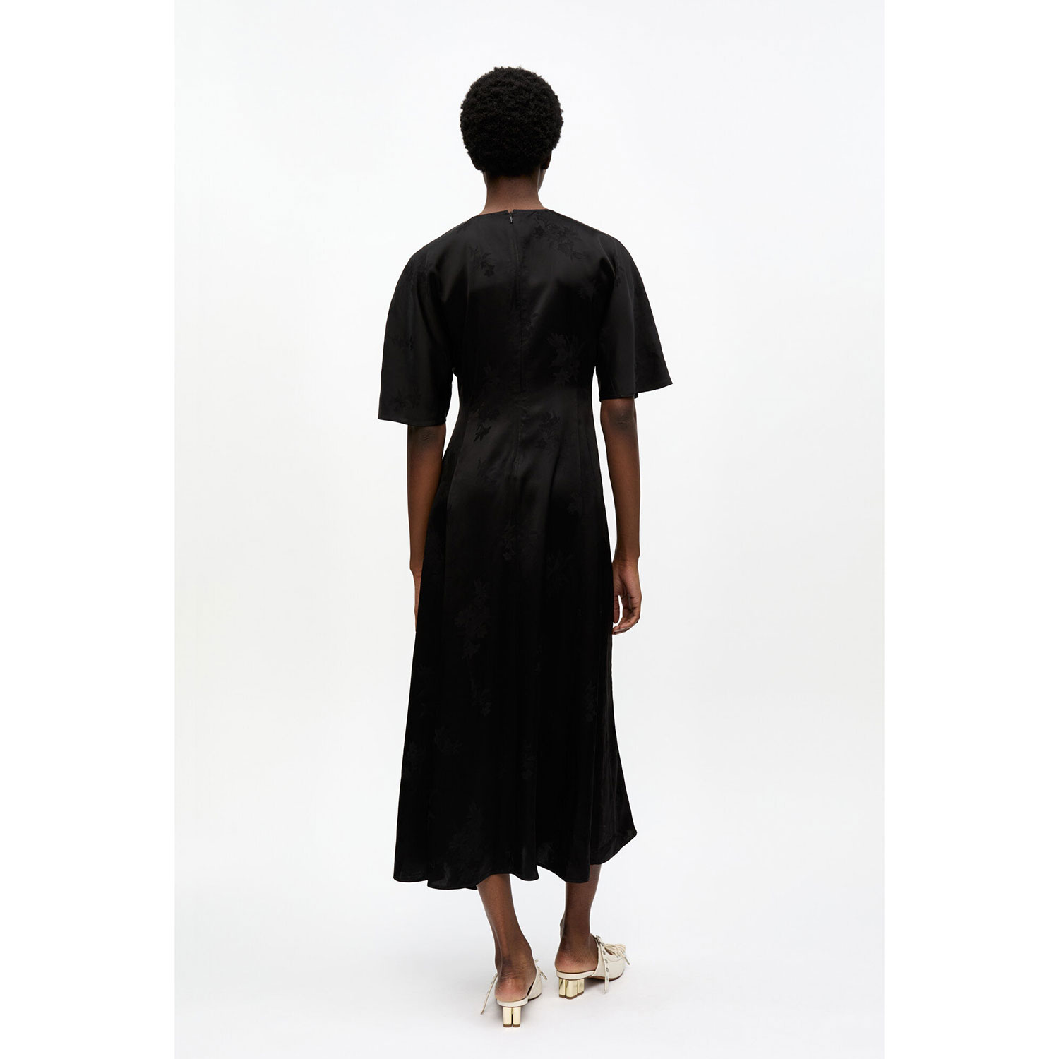 Ganni W0255 Satin Maxi-Kleid mit Rundhals-Ausschnitt und kurzen Ärmel und Jacquardmuster in Schwarz von Ganni. Model hinten