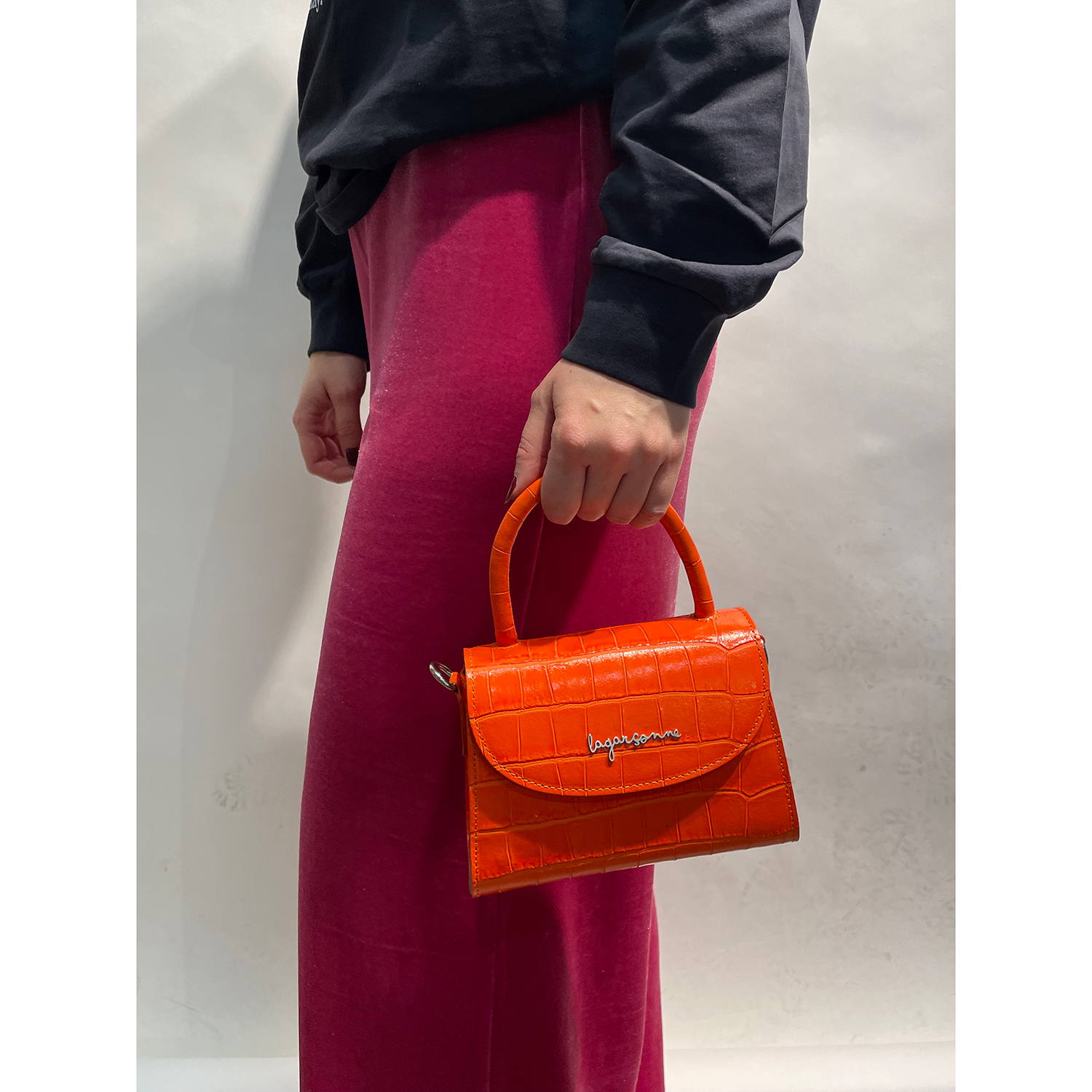 La Garçonne Accessoires Amari Mini Tasche in Schwarz aus echtem Leder mit Kroko prägung von La Garçonne Accessoires Model vorne