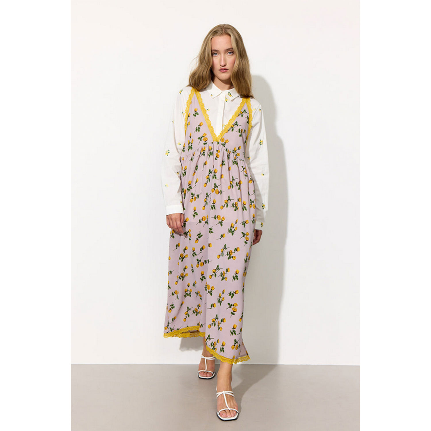 Hunkøn Lisa Kleid mit V-Ausschnitt vorne und hinten und Spitzendetails mit Blumenpring von Hunkøn. Model vorne