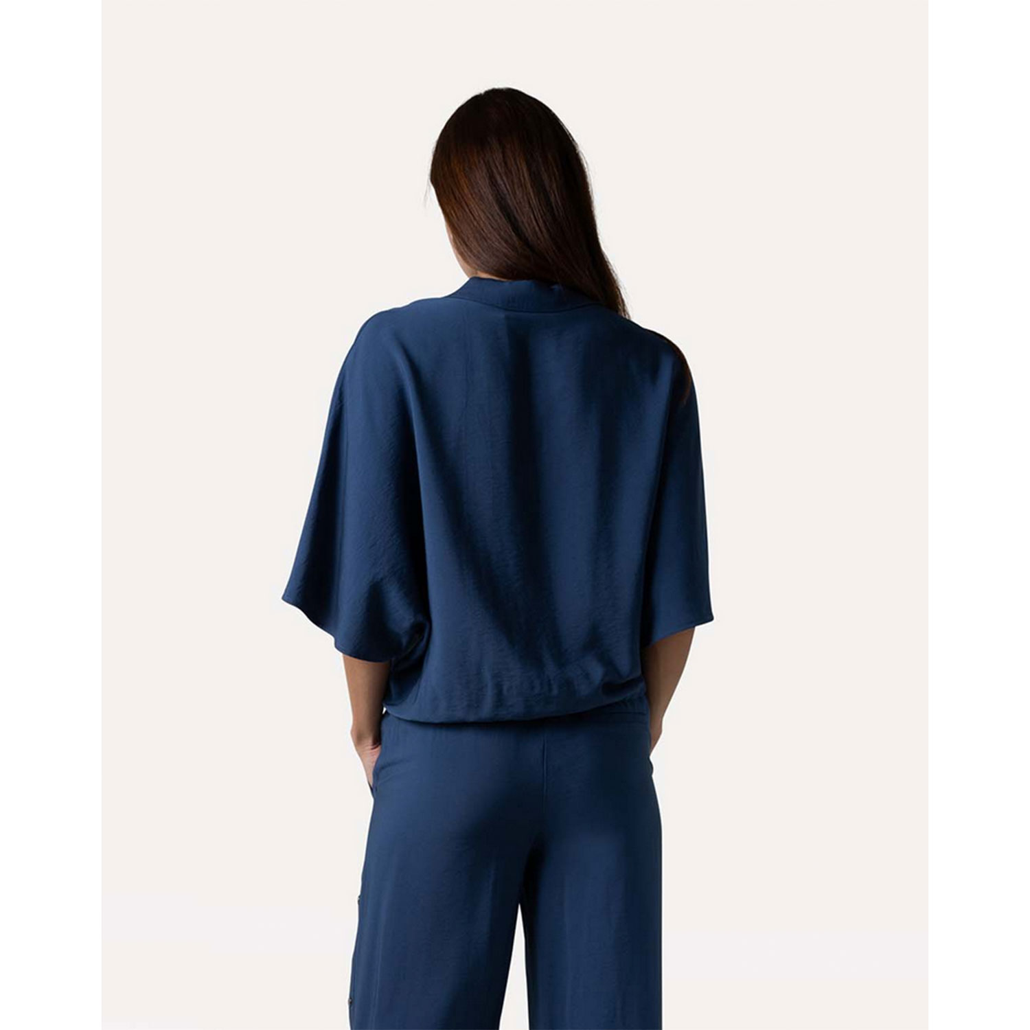 Another Label Rila kurzarm Bluse mit Chemisekragen, Knopfleiste und Kordelzug am Saum in Blau von Another Label. Model hinten