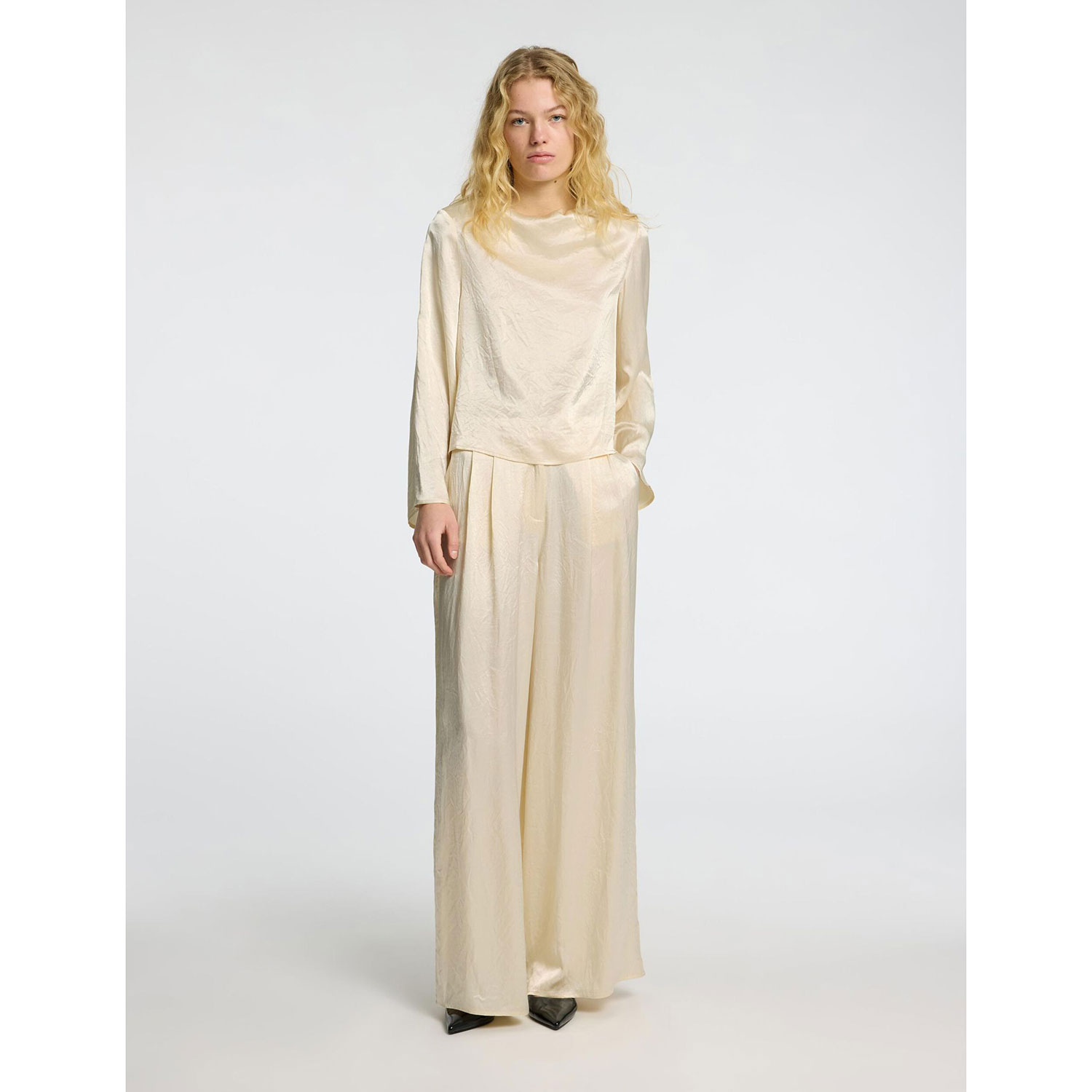 Selected Femme Selene Satinhose mit Bundfalten in Ecru von Selected Femme. Model vorne